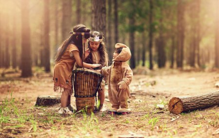 Native American children, drum and happy for music with playing, bonding and connection in woods. Siblings, kids and instruments with culture, heritage and history in forest with family in California.