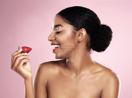 Photo for Smile, profile and black woman with strawberry for nutrition, health and healthy diet isolated on pink background. Skin, gen z girl with fruit for food, wellness and happy on studio backdrop. - Royalty Free Image