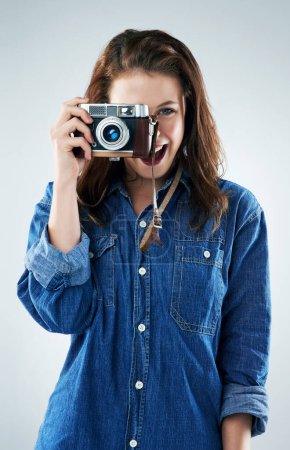 Photo for Woman, photographer and vintage camera in studio for newspaper, magazine and job at media company. Girl, paparazzi and retro tech for photoshoot, creativity and smile for story by white background. - Royalty Free Image