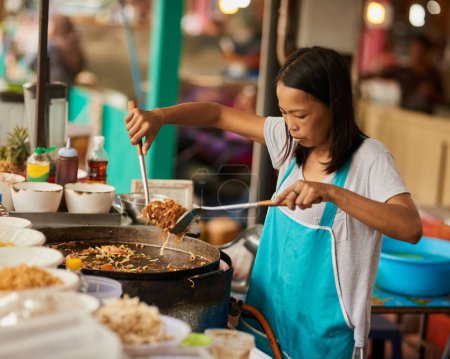 Photo for Woman, food market and cooking with vendor, ingredients and prepare meal with utensils, fried cuisine or informal business. Traditional, street chef or entrepreneur with culture, startup or Thai dish. - Royalty Free Image
