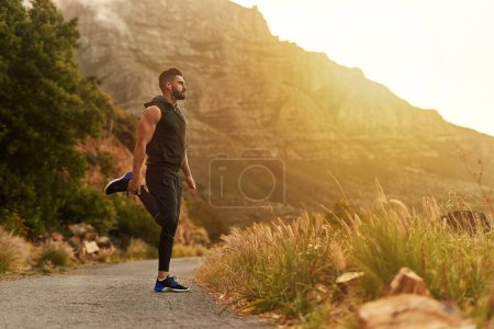 Photo for Man, mountain and stretching with headphones in fitness for training, exercise or workout music. Male person, runner and thinking in nature with preparation for balance, sports or podcast for warm up. - Royalty Free Image