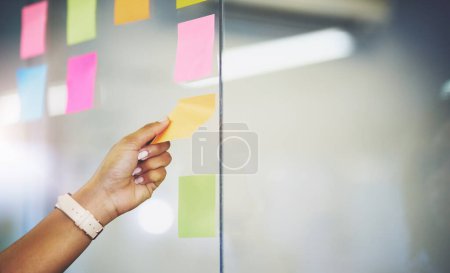 Photo for Hand, sticky note and glass wall for brainstorming solution for tech startup or moodboard, project planning or idea. Person, fingers and creative inspiration for company growth or goal, future or job. - Royalty Free Image