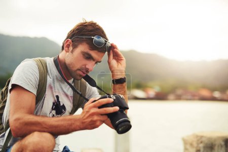 Man, camera and travel photographer at mountain as photo journalist for tourism, hobby or water. Male person, pictures and outdoor creative at sea in Australia or blog equipment, view or professional.
