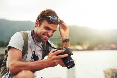 Man, camera and travel photographer at ocean as photo journalist for tourism, hobby or water. Male person, pictures and outdoor creative at sea in Australia or blog equipment, view or professional.