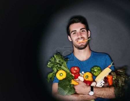 Foto de Hombre, retrato y estudio con verduras para dieta o nutrición, vegano con salud y bienestar. Hombre, comestibles y fondo negro para el anuncio con comida o compras, feliz con hierbas. - Imagen libre de derechos