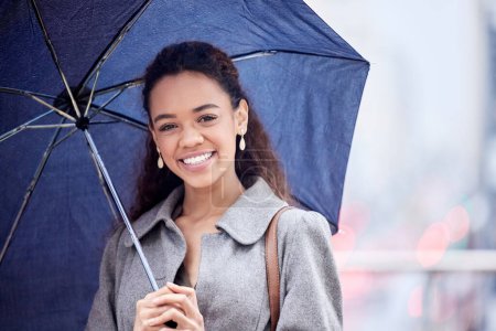 Foto de Mujer negra, paraguas y lluvia con sonrisa, feliz y disfrutar del tiempo en la ciudad siendo mojado. Invierno, joven escritor y alegría por la tormenta, alegre y alegre con cubierta, cómoda y lluviosa Nueva York. - Imagen libre de derechos