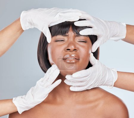 Photo for Eyes closed, black woman and hand gloves for plastic surgery with concern and stress in a studio. Cosmetics, doctor and facial treatment for anti aging and dermatology consultation with pain and hurt. - Royalty Free Image