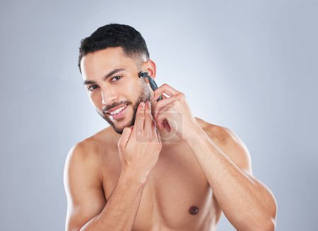 Photo for Skincare, body and portrait of man shaving face in studio for wellness, hygiene and cosmetic treatment on grey background. Happy, beauty and Mexican model with facial, hair removal and razor blade. - Royalty Free Image