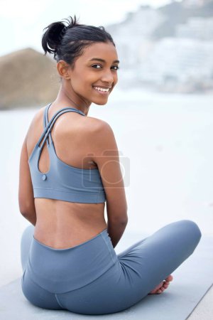 Photo for Indian woman, yoga and happiness in nature for relax, wellness and meditation at beach. Healthy female person, smile and fitness by ocean for zen, spiritual and balance outdoor for holistic healing. - Royalty Free Image