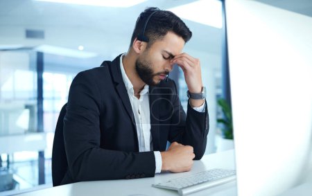 Photo for Man, headache and frustrated in call center with computer in office, stress and anxiety from customer support. Worker, operator and telemarketing with sales consultant, mental health and tired - Royalty Free Image