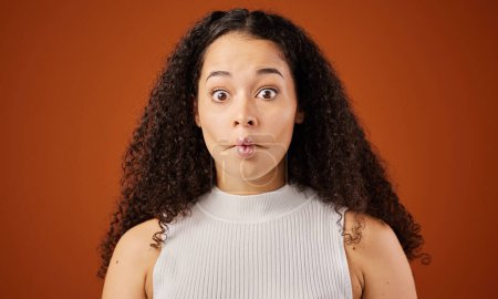 African woman, portrait and studio with fish lips for comedy, gesture with face or comic. Female comedian, brown background and surprise with sucking mouth for expression, funny or joke in Namibia.