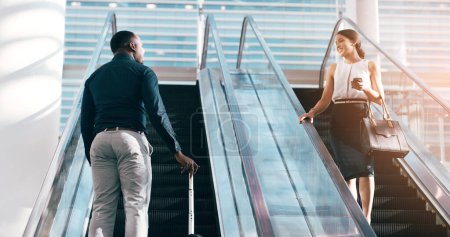 Téléchargez les photos : Les gens d'affaires, accueil et escalator avec bagages à l'aéroport pour le voyage de travail, Voyage ou opportunité. Homme d'affaires heureux et femme parlant sur escalier électrique ou ascenseur pour l'immigration avec des sacs. - en image libre de droit