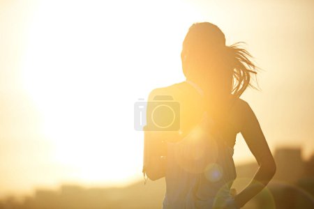 Photo for Woman, running and back in sunrise for training by mockup space for silhouette with sky in city. Girl, person and athlete with workout, exercise or wellness for marathon, challenge or fitness in road. - Royalty Free Image