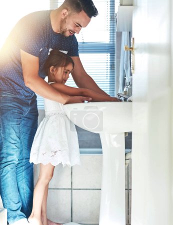 Photo for Father, girl and washing hands in bathroom for skincare, bacteria and learning to remove germs or dirt. Daddy, daughter and water for cleaning in home, teaching and disinfection for child development. - Royalty Free Image
