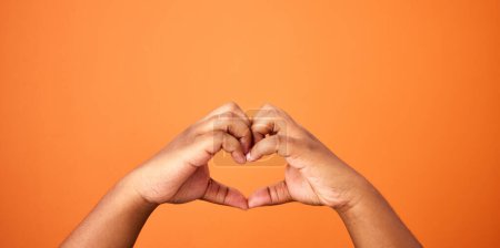 Photo for Love, hands and heart shape in studio for care, support and romance on orange background. Person, symbol and icon for affection with emoji, trust and peace for valentines day with mockup space. - Royalty Free Image