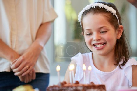 Photo for Girl, happy and candles for birthday cake, surprise and celebration in Germany house with kid. Child, smile and love or homemade chocolate dessert, excited and support or together family dinner. - Royalty Free Image