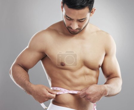 Photo for Man, tape measure and lose weight results in studio or waist size for progress, grey background or athlete. Male person, shirtless and workout training or diet for bodybuilder abs, growth or muscle. - Royalty Free Image