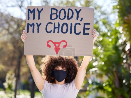 Téléchargez les photos : Femme, portrait et affiche pour protester en plein air contre l'avortement, le choix du corps ou la liberté des droits de l'homme. Féminisme, carton et femme avec masque pour l "égalité, changement politique ou décision sûre. - en image libre de droit