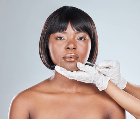 Photo for Hands, African woman and syringe for lip filler in studio for plastic surgery, beauty or change by white background. Girl, portrait and chemical for cosmetics, injection and liquid for transformation. - Royalty Free Image