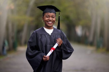 Téléchargez les photos : Black girl, portrait and diploma for graduation in outdoor, certificate and college or education achievement. Female person, student and degree for learning, scroll and campus ceremony at university. - en image libre de droit