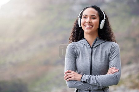 Photo for Mountains, headphones and woman with arms crossed, fitness and exercise with wellness, smile and streaming music. Person, girl or runner with headset, progress and outdoor for workout, audio or sound. - Royalty Free Image