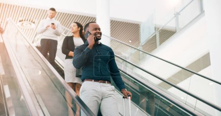 Photo for Black man, escalator and talking with phone call for discussion or communication on work trip. Businessman speaking on mobile smartphone in travel with luggage for immigration or new opportunity. - Royalty Free Image