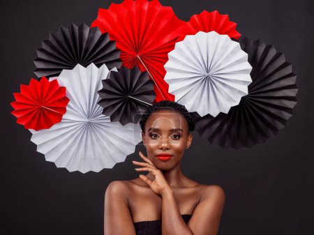 Téléchargez les photos : Femme noire, fans d'origami et de beauté avec mode esthétique, maquillage et art pour la culture en studio. Femme ou modèle africain et artisanat traditionnel ou design créatif avec fond sombre. - en image libre de droit