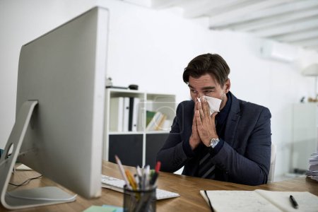 Téléchargez les photos : Sinus, éternuements et homme d'affaires au bureau avec allergies, nez et virus qui travaillent au bureau. Travailleur d'entreprise, les soins de santé et la personne avec des tissus pour la maladie, le rhume et la grippe éternuer sur le lieu de travail. - en image libre de droit