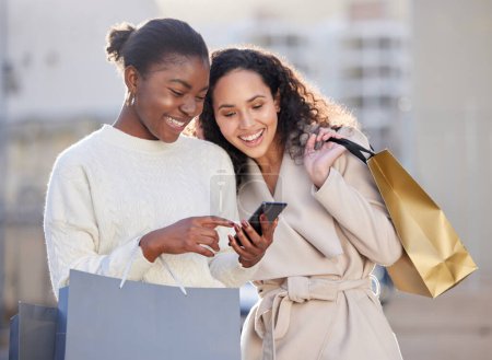 Téléchargez les photos : Femme, shopping et heureux avec smartphone en ville, ventes en ligne et amis rire ou sourire pour la vente au détail. Rabais, technologie et centre-ville urbain, mode et recherche sur l'application de médias sociaux. - en image libre de droit