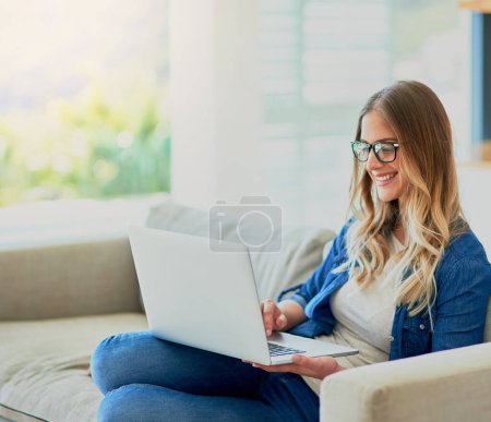 Photo for Woman, happy and relax on sofa with laptop for online streaming entertainment, social media memes and comedy movie. Girl, home and technology with internet for reading articles or ebooks and websites. - Royalty Free Image