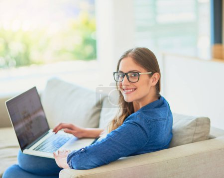 Woman, portrait and relax on sofa with laptop for online streaming entertainment, social media memes and remote job. Girl, home and technology with internet for reading articles or ebooks and website.