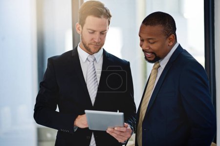 Business partners, men and tablet in office for discussion, advice or consulting in lobby at law firm. People, lawyers and meeting for update, informing or ideas in workplace for client, work or task.