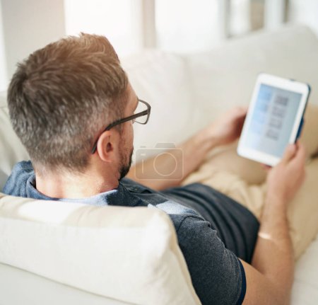 Photo for Tablet, screen and man relax on a sofa with social media, search or internet, scroll and streaming subscription at home. Digital, ecommerce and living room with online shopping, app or menu choice. - Royalty Free Image