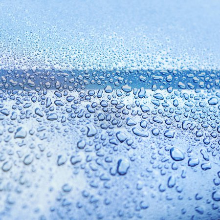 Foto de Agua, gotas y húmedo en la superficie azul en la naturaleza para el papel pintado, fondo y texturas en el medio ambiente. Lluvia, ventana y líquido en la pantalla para la limpieza, vidrio y primer plano de exterior liso en la ducha. - Imagen libre de derechos