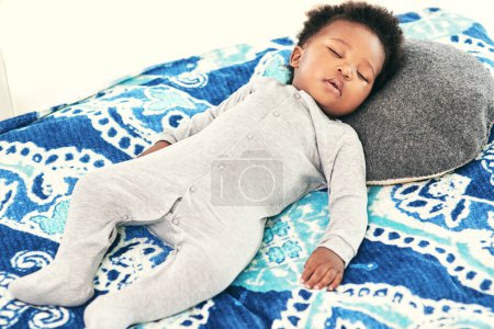 Foto de Dormir, bebé y niño negro en la cama en el dormitorio para descansar, cansado o en desarrollo. Niño recién nacido, relajado y dulce que yace en la habitación de la guardería para una cómoda y acogedora siesta matutina o para soñar en casa.. - Imagen libre de derechos