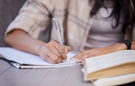 Photo for Notebook, girl and hand with studying on table for education, learning or knowledge in assignment. University, student and writing with pen on desk for literature scholarship, planning or development. - Royalty Free Image