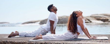 Téléchargez les photos : Couple, yoga et plage pour le bien-être sur tapis, le lien relationnel et la santé du corps ou étirer avec l'exercice. Entraînement spirituel, holistique et pratique de la confiance ou méditation extérieure, de l'océan et de la pleine conscience. - en image libre de droit