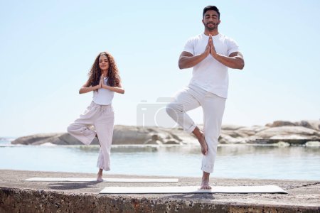 Photo for Yoga, prayer hands and couple with meditation by ocean for spiritual fitness, mental wellness and namaste. Outdoor, pilates and yogi people with eyes closed for mindfulness, balance or tree pose. - Royalty Free Image