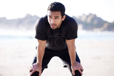 Photo for Asian man, fitness and exhausted with break at beach for sports, exercise and training for body health. Male athlete, breathe and tired from workout with run fatigue, recovery and cardio in nature. - Royalty Free Image