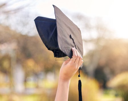 Photo for Person, nature and hand with graduation cap at university for education, success and academic growth. Student, future and celebration with hat at academy for scholarship, knowledge and achievement. - Royalty Free Image