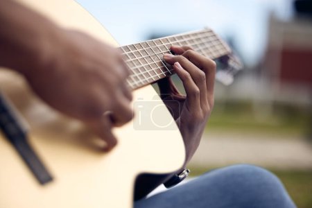 Photo for Man, guitar and hands in garden for music, sound and performance in nature. Gen z male person, musician and playing instrument at university for practice, production and rehearsal for rock show. - Royalty Free Image