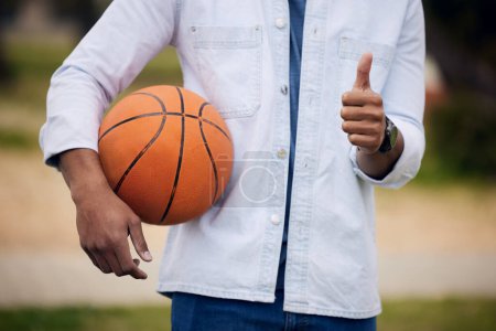 Man, student and hands with basketball or thumbs up for winning, vote or review at unversity campus. Closeup of male person, athlete or player with like emoji, yes sign or OK in sports, game or match.