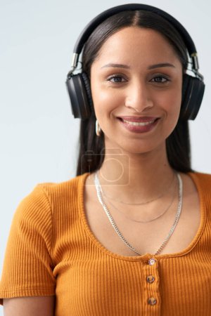Photo for Woman, smile and portrait with headphones in studio background for listening to music, podcast or radio. Girl, happy and headset on with playlist subscription for streaming audio, sound or song. - Royalty Free Image