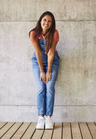 Photo for Fashion, smile and portrait of woman by wall with casual, trendy and dungaree outfit with sneakers. Happy, stylish and full body of female person with denim, trendy and funky clothes for confidence - Royalty Free Image