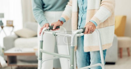 Téléchargez les photos : Woman, hands and walker in elderly care for physiotherapy, support or trust at old age home. Closeup of female nurse or caregiver walking and helping patient or person with a disability in the house. - en image libre de droit