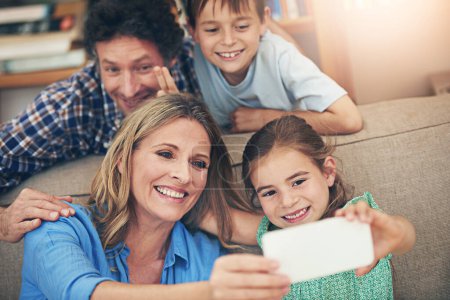 Glückliche Familie, entspannen und Selfie mit Friedenszeichen auf dem Sofa für Erinnerung, Bild oder Bindung zusammen zu Hause. Mama, Papa und kleine Kinder mit Lächeln für Fotos, Aufnahmen oder Momente auf der Wohnzimmercouch.