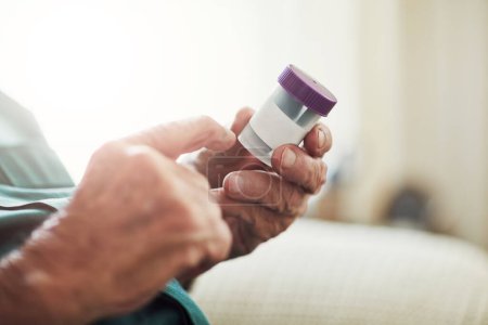 Foto de Senior man, hands and reading medication with pills for prescription, chronic illness or sickness at old age home. Closeup of elderly male person checking container for medical dose or side effects. - Imagen libre de derechos