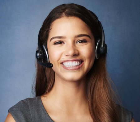 Téléchargez les photos : Girl, smile and studio portrait for call center work, telemarketing career and virtual assistant for outbound sales company. Woman, blue background and faq for contact us, communication and support - en image libre de droit