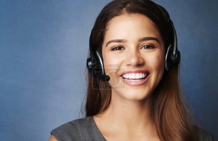 Téléchargez les photos : Businesswoman, portrait and studio with headset, smile and communication for goals. Agent, call center operator or reporter for content creation, publishing or press startup on blue background. - en image libre de droit