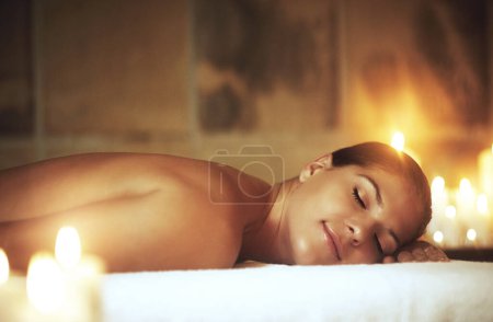Téléchargez les photos : Woman, relax and spa treatment on massage bed for glow, wellness and cosmetics with candles. Zen, beauty and sleeping with peace after aromatherapy, deep tissue and stress relief with oil for luxury. - en image libre de droit